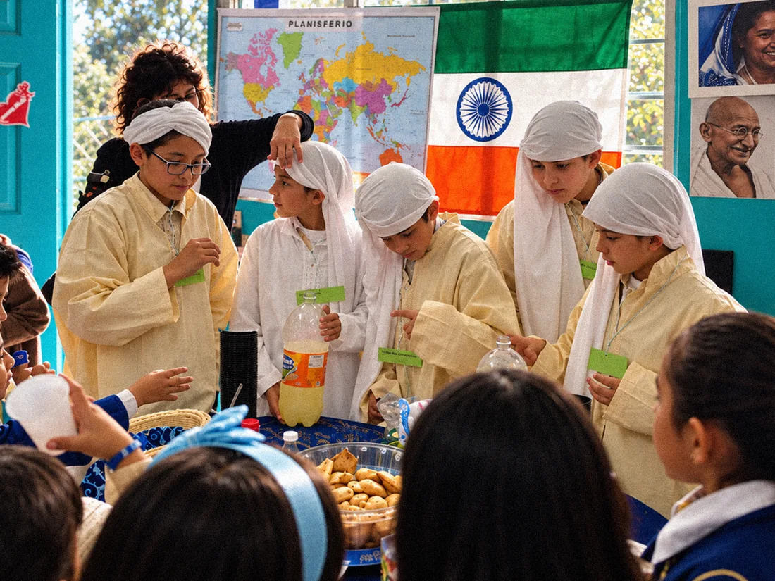 Estudiantes con vestimenta cultural presentan una actividad de alimentos y geografía